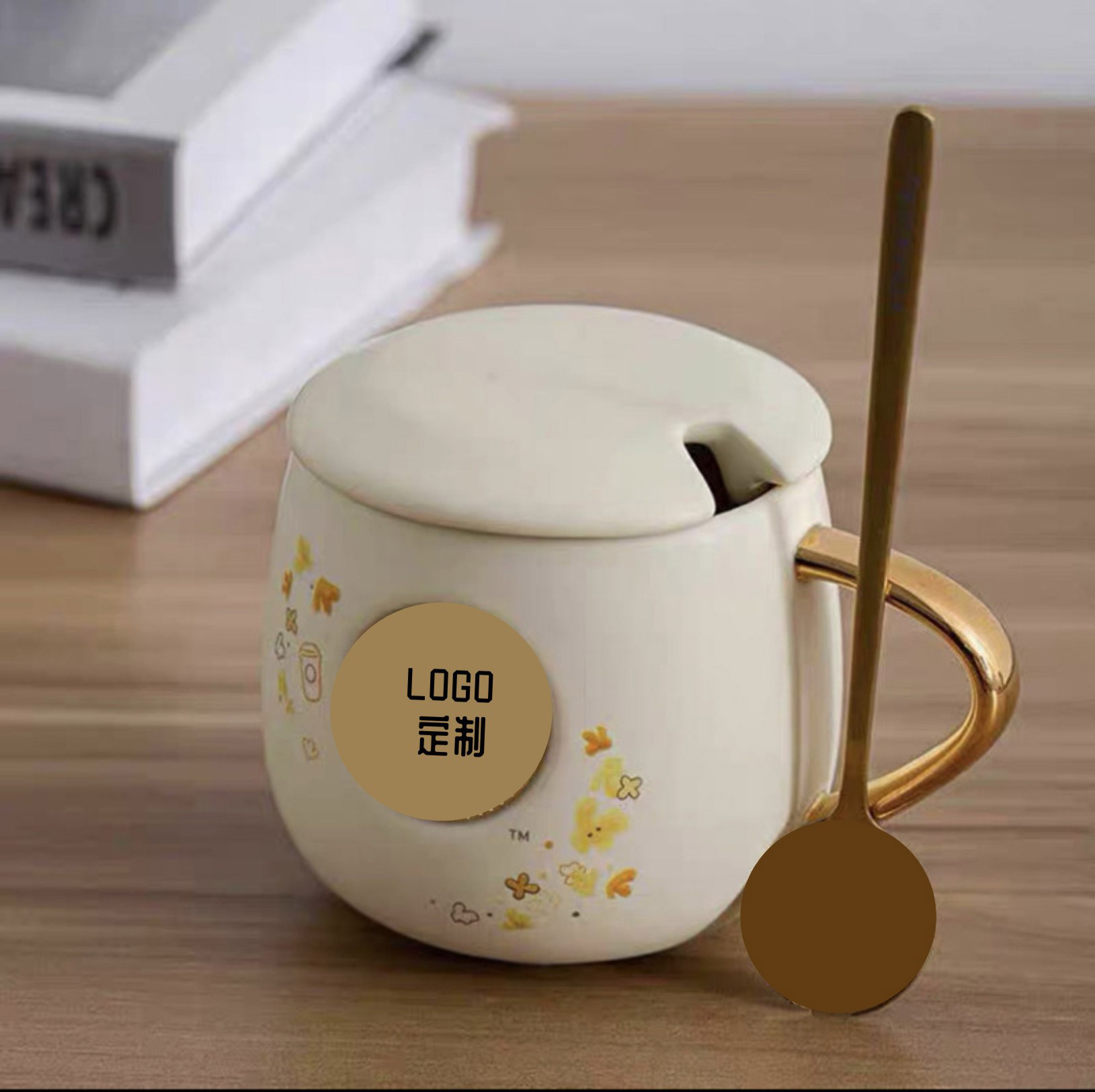 Cốc cà phê khối tròn hình hoa mộc vàng kèm muỗng, in logo theo yêu cầu. Giá cạnh tranh. Chất liệu: Gốm sứ. Quà tặng doanh nghiệp phổ biến
