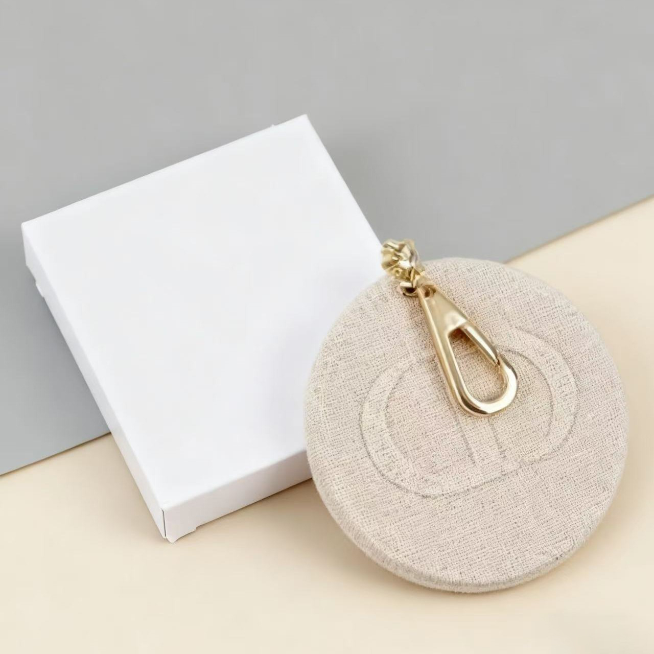 Gương trang điểm móc khoá Dior được cấu tạo bởi 2 thành phần: 1 miếng nắp gương có thêu nổi logo Dior, và 1 miếng có đính gương chắc chắn.